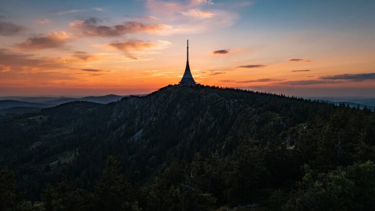 Kuzelova vez na zalesnenem hrebeni proti vecerni obloze